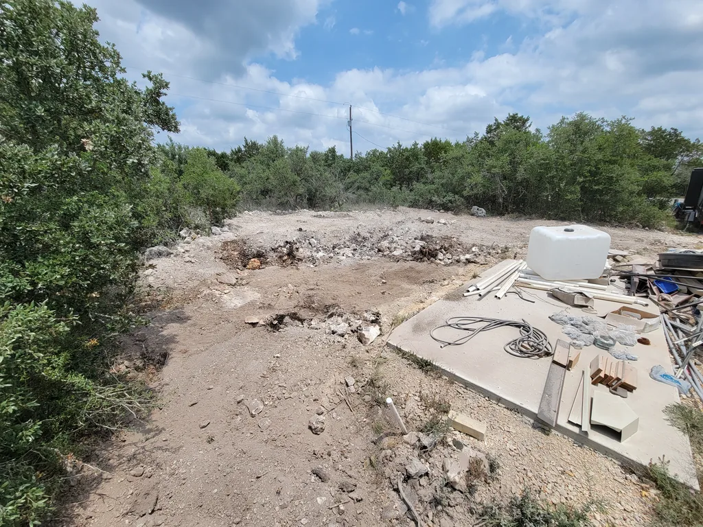 Old concrete slab and debris on a cleared lot after a teardown, light demolition