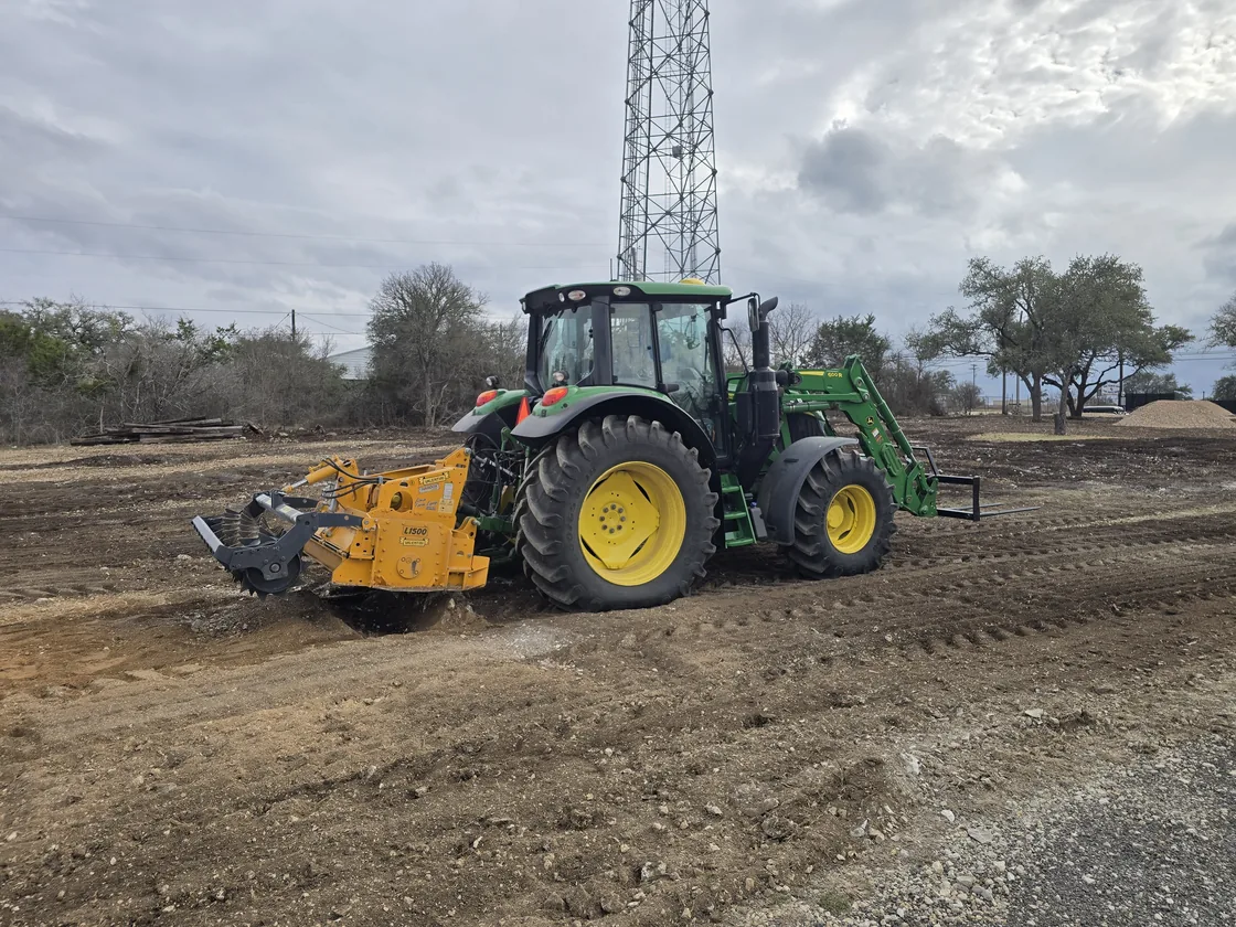 Tractor with a rock mill grinding rocky ground into crushed base, rock milling